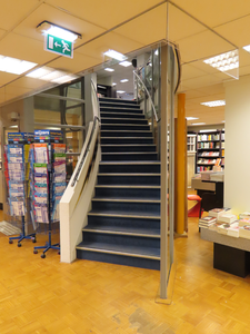 848617 Interieur van boekhandel Broese Boekverkopers (Stadhuisbrug 5) te Utrecht: de trap naar de begane grond, in de ...